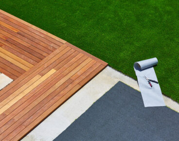 Artificial grass turf installation in deck garden with tools and joint roll